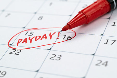 a desk calendar with a date circled in red with the word payday splashed across it