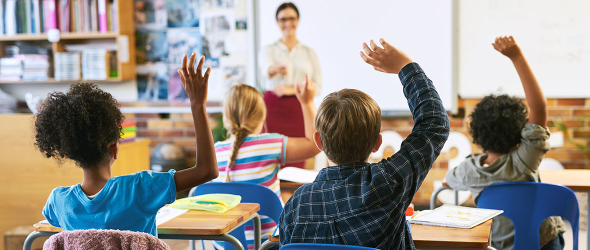 Students raising hands in class