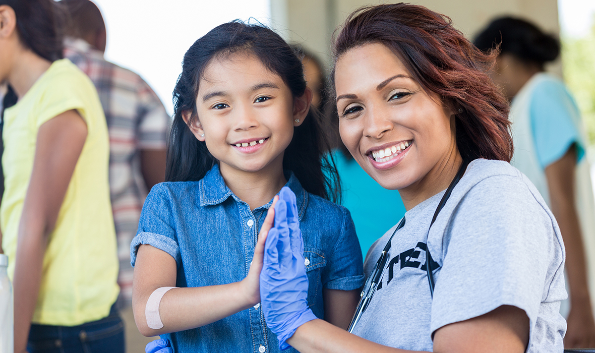 Public Health official smiling with child