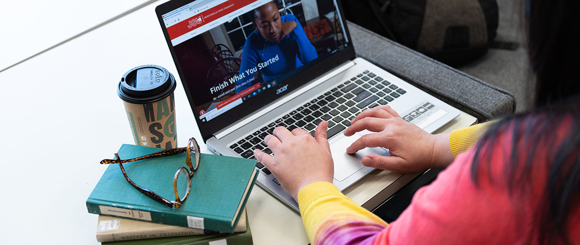 Student typing on laptop computer