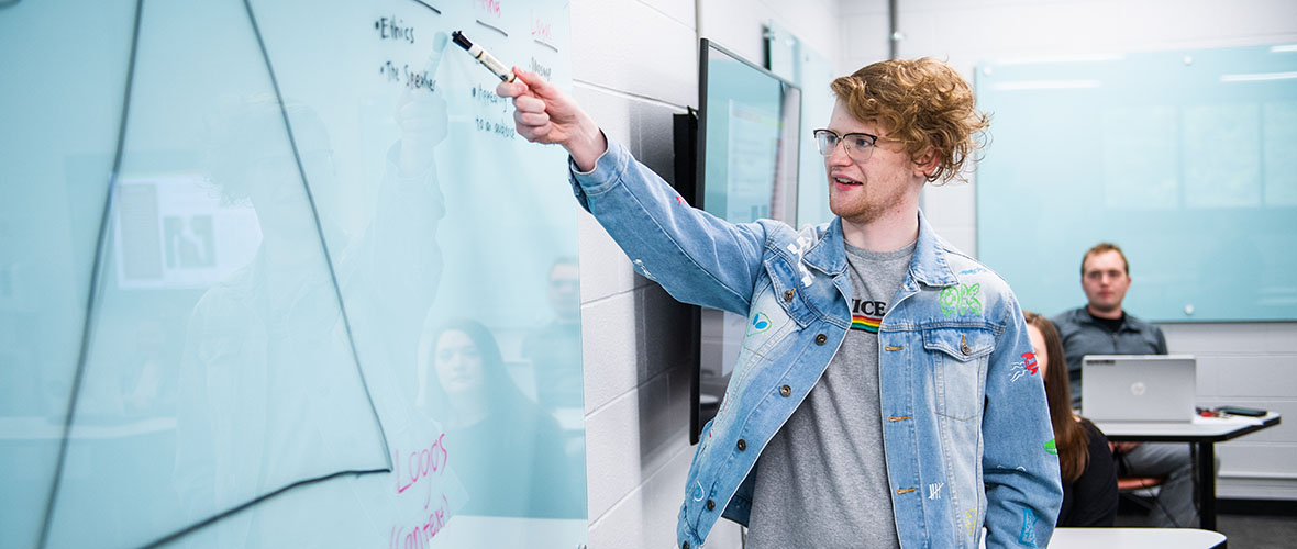 Student writing on whiteboard