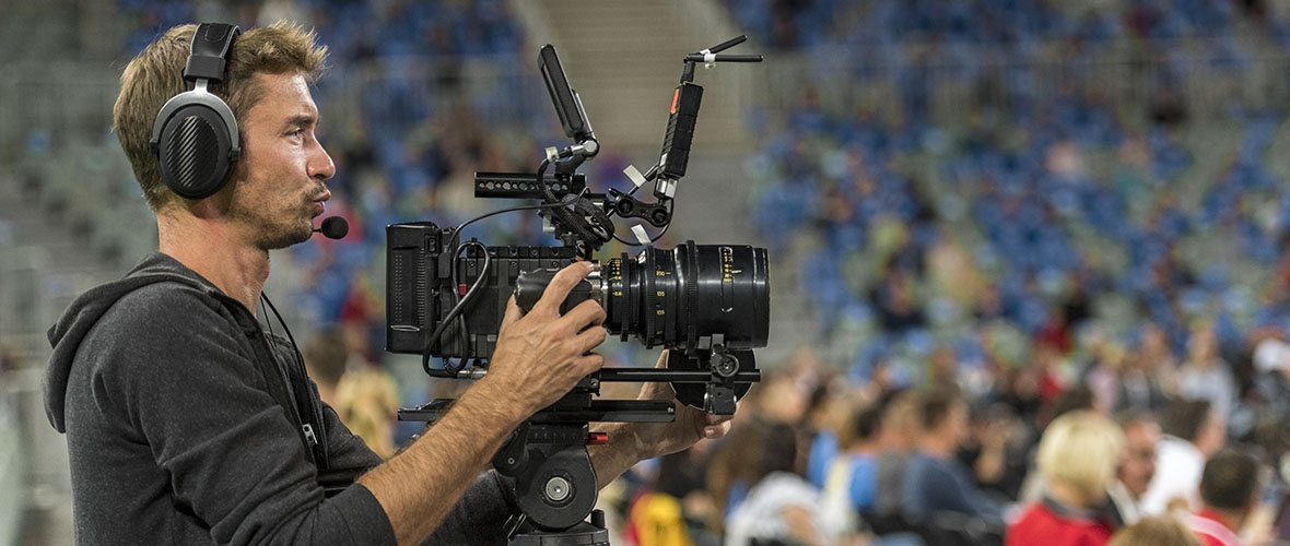 A Sports Media professional with a camera at a sporting event