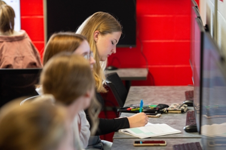 Students sitting at computer desks. 
