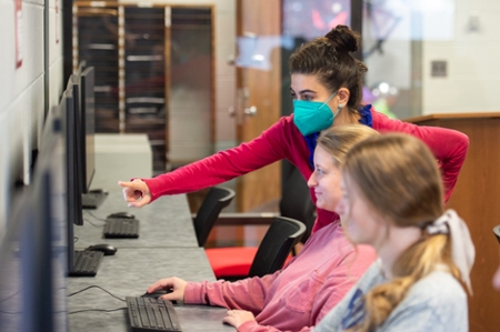 Professor helping students with work.  