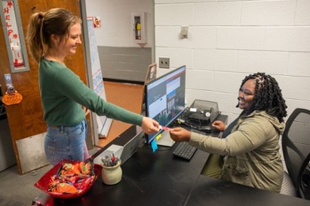 Director giving student ID card.  