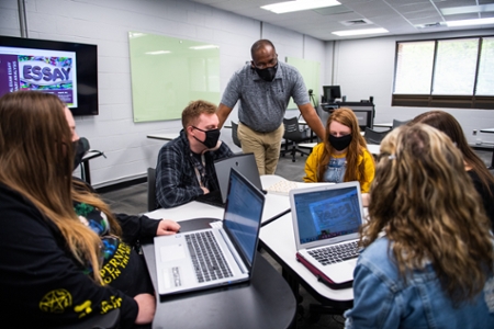 A teacher talking to a group of students. 