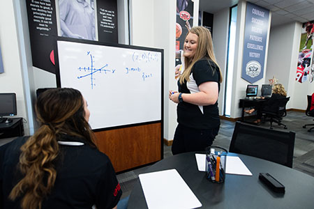A tutor gives instructions to students