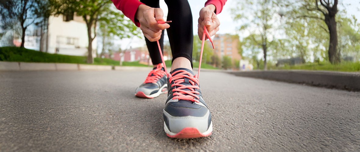 Female walker lacing up her shoes